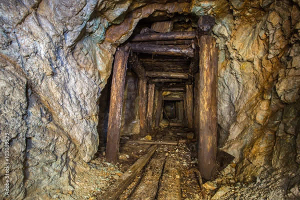 Fototapeta Old abandoned gold ore mine tunnel with wood timbering in Ural