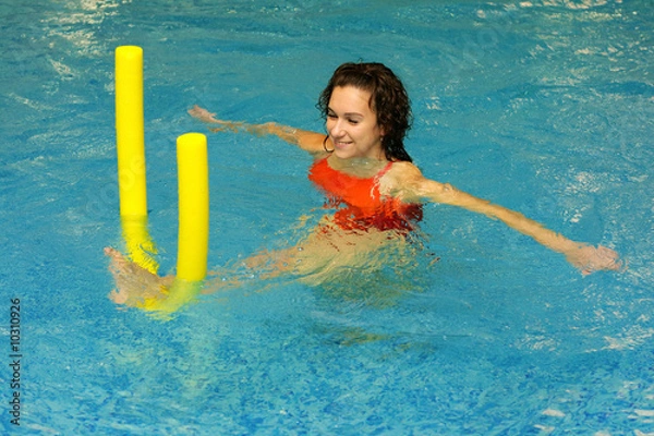 Obraz The young girl does exercise with aqua noodles