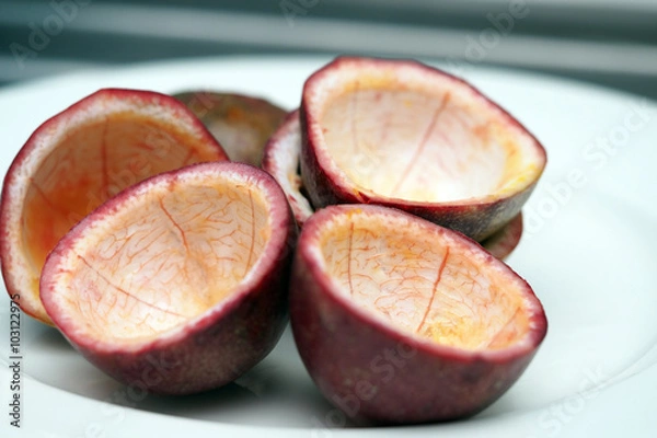 Fototapeta Passion fruit half cut empty inside on white dish