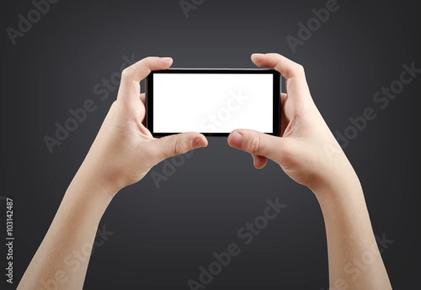 Obraz Two hands holding big screen smart phone, isolated on dark background, clipping path