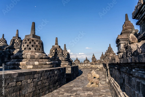 Fototapeta Many Stupas on top of Borobudur Temple - an important historical Buddhist monument in Magelang, Indonesia. Moon visible in sky.