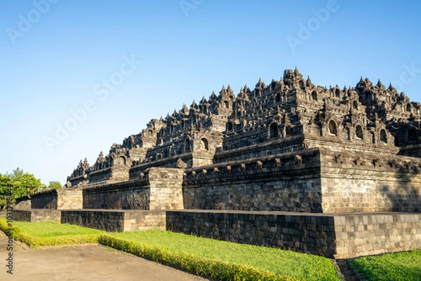 Fototapeta Borobudur, Mahayana Buddhist Temple in Indonesia - Mageland, Yogyakarta. Wide Angle of ancient stupa pyramid from north-west corner.