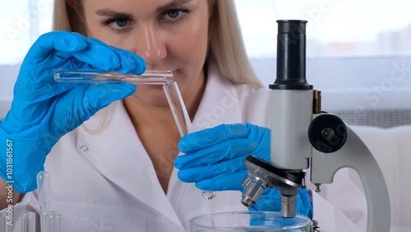 Fototapeta professional scientist takes a sample for a medical experiment. A research chemist works in a laboratory with a micropipette and a microscope