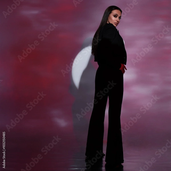 Obraz beautiful fashion girl posing in the studio in a classic black suit illuminated by colored light