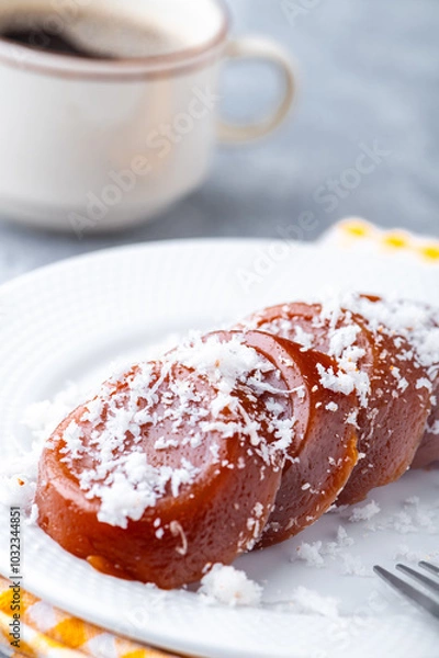 Fototapeta Pinoy puto kutsinta, is a type of steamed rice cake popular as street snack or merienda. It is made from a blend of rice or tapioca flour, brown sugar, and lye, giving it its distinct chewy texture.