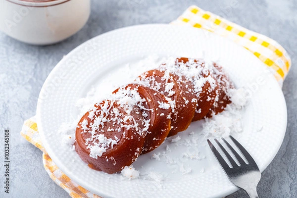 Fototapeta Pinoy puto kutsinta, is a type of steamed rice cake popular as street snack or merienda. It is made from a blend of rice or tapioca flour, brown sugar, and lye, giving it its distinct chewy texture.