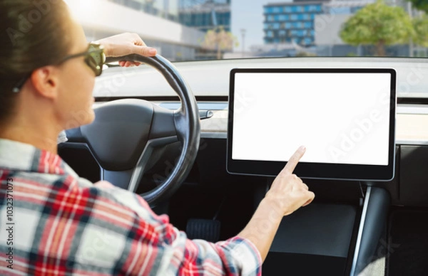 Fototapeta Woman engaging with infotainment system in electric car interior, mockup touchscreen display.