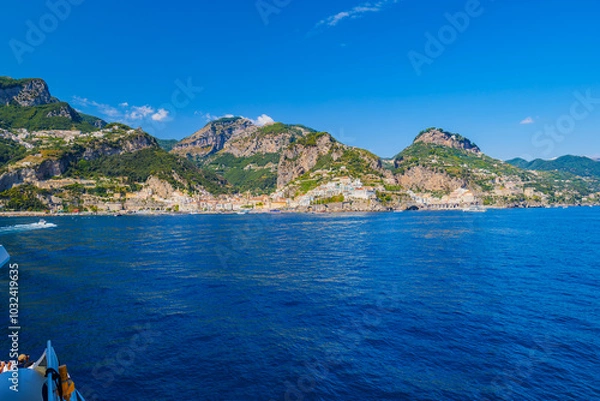 Fototapeta Amalfi, Italy. View of Amalfi and Amalfi Coast from the ferry. Seaside village with green mountains of Monti Lattari in Campania, Italy. Seascape from the sea on a sunny summer day on Amalfi, Atrani.