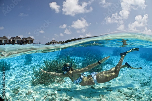 Fototapeta BETWEEN TWO WORLDS. Having the chance to grab you mask, fins & snorkel and jump out of your water villa to splash yourself with crystal clear warm water is PRICELESS!