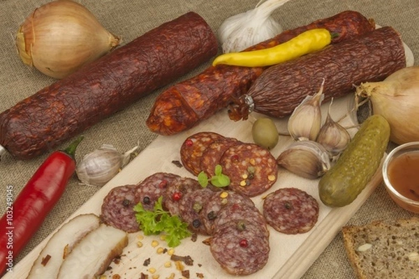 Fototapeta 
Spicy sausages on a wooden cutting board. Preparing the menu. Entertainment for visitors. Production of delicious sausages.
