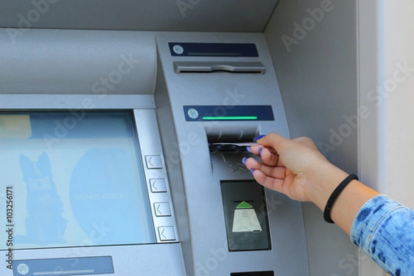 Obraz woman hand inserting credit card to ATM