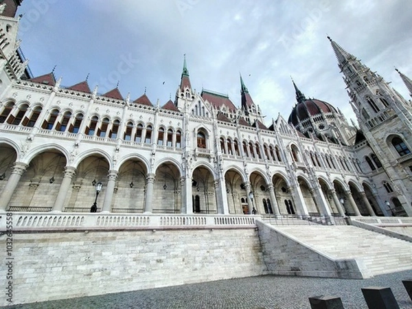 Obraz A wide view of the Hungary Parliament building, with the large central dome and ornate arches in full display. This angle highlights the building’s stunning symmetry and intricate details.