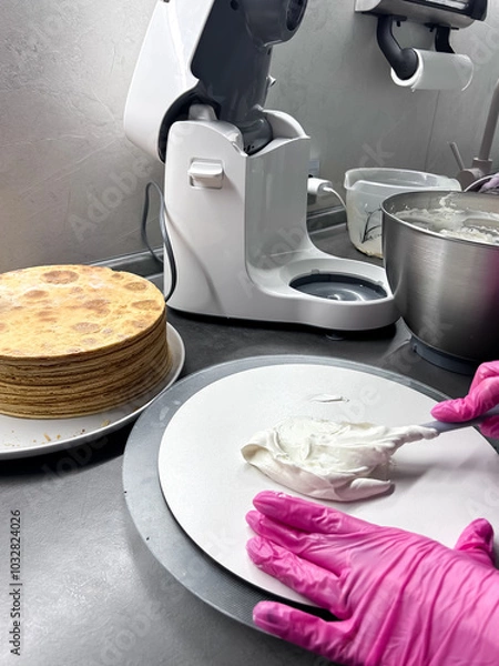 Fototapeta The process of making a cake at home. Honey cake. Layer the cakes with cream. Cooking desserts