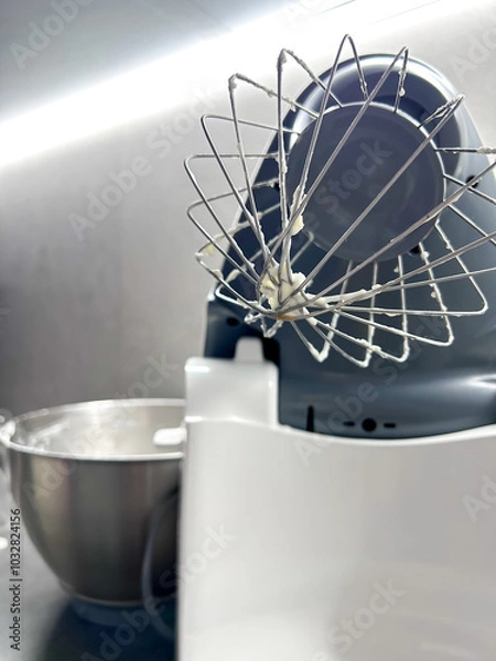 Fototapeta Mixer in the kitchen at home. Equipment for making cream. Professional mixer is on the table. Mixer whips cream. Pastry tools. Making a cake