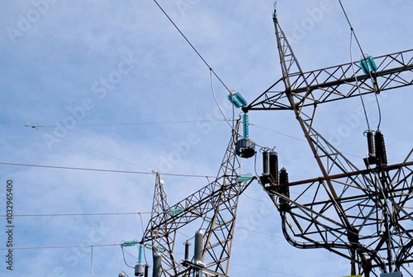 Fototapeta Electricity pylons with a clouded sky in the background