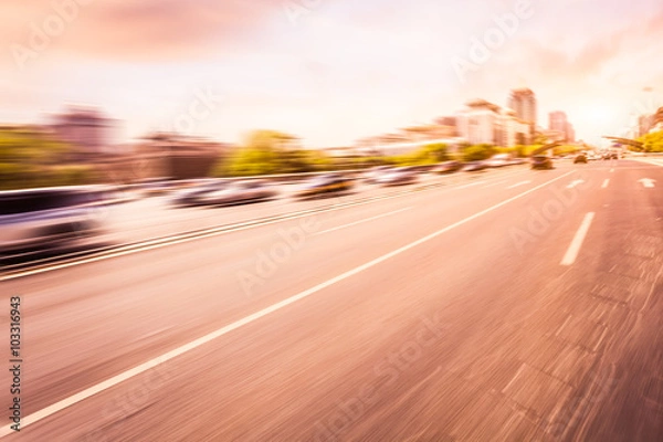 Fototapeta Car driving on road at sunset, motion blur