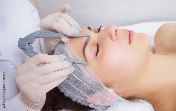 Obraz tattooist is using tool to measure eyebrows