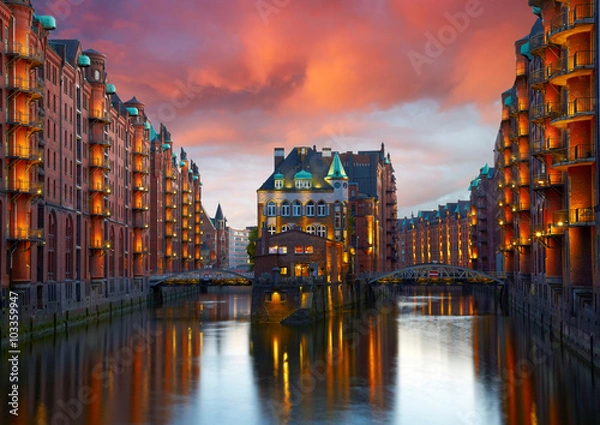 Obraz Stare Speicherstadt w Hamburgu oświetlone nocą. Zachód słońca w tle