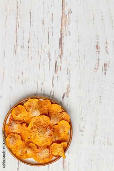 Fototapeta Frozen chanterelles in a plate on the table. Forest mushrooms. Selective focus