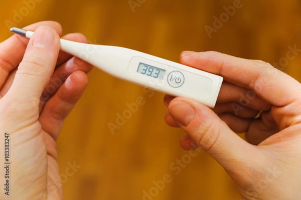 Obraz hands hold thermometer with high temperature on screen