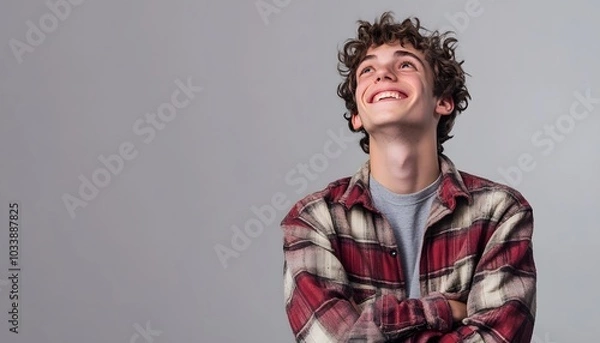 Obraz Smiling Young Man Looking Up with Crossed Arms