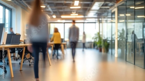 Fototapeta Blurry view of diverse professionals in a modern office setting, creating a dynamic atmosphere.