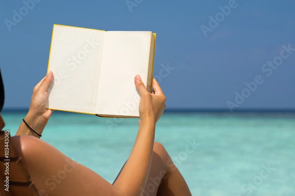 Fototapeta Reading book in the beach, hands holding book with blank pages,