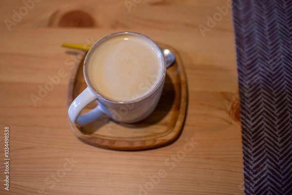 Obraz A cup of coffee stands on a wooden table