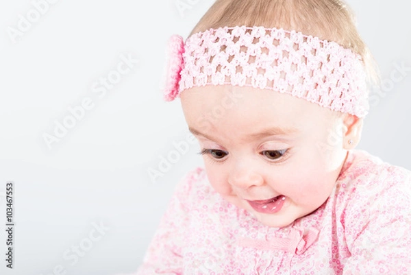 Fototapeta Portrait of 1 year old baby girl against grey background with copy space being amazed of her discovery