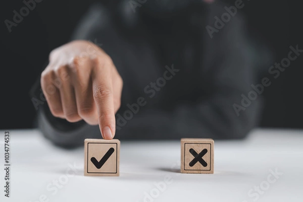 Obraz Businesswoman select correct sign mark between Cross mark which print screen on wooden cube block for approve and reject business proposal concept.