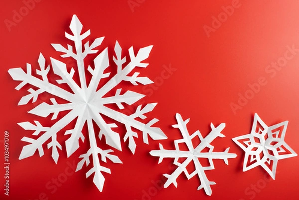 Obraz white paper cut out snowflakes in red background. Empty space for copy space. winter or christmas theme background. selective focus.