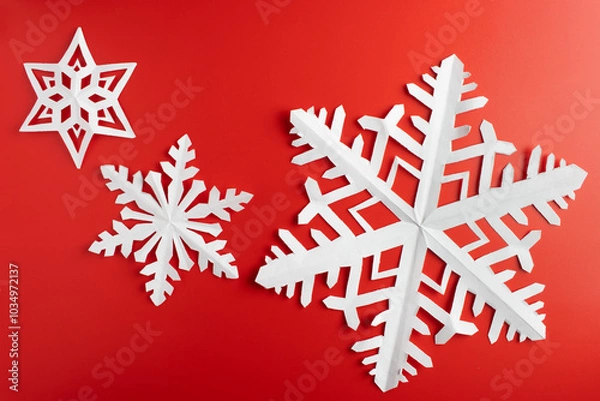 Obraz white paper cut out snowflakes in red background. winter or christmas theme background. selective focus.