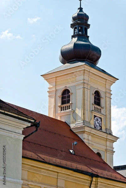 Fototapeta A baroque-style church tower in Sibiu, Romania, featuring an onion-shaped dome, a clock face, and arched windows.
