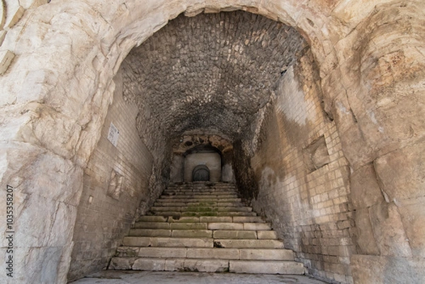 Fototapeta Wander through the ancient stone pathways of the Arles Roman Era Amphitheater, where cave-like passages and carved steps create a mystical journey. Each step echoes with history, inviting exploration
