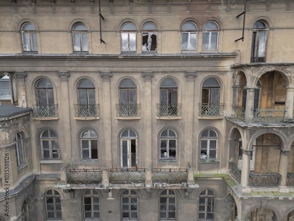 Fototapeta Historic old 19th 20th century ruined derelict abandoned hotel house building facade scene, with arcade decorated terrace and greek style columns