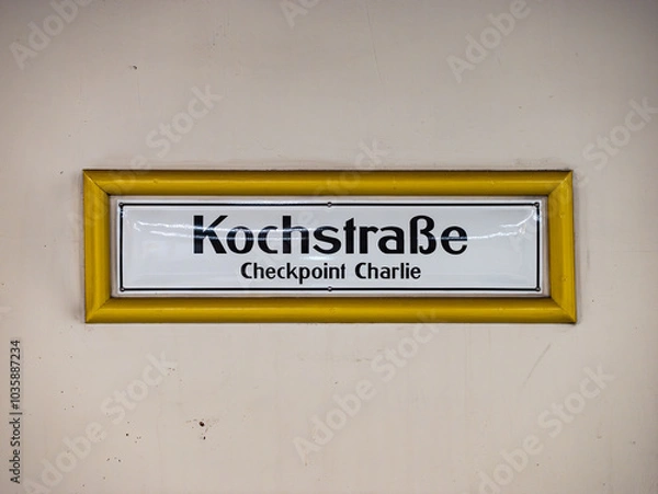 Obraz Kochstraße sign at the underground train station in Berlin Kreuzberg, Germany. Location name of the public transportation. White wall with black letters on white. Checkpoint Charlie as destination.
