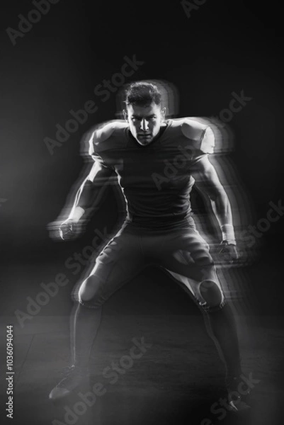 Fototapeta American Football Player in Action: A dynamic, motion-blurred image of an American football player in a powerful stance, ready for the next play.