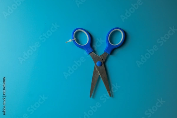 Obraz children's scissors working on a blue table
