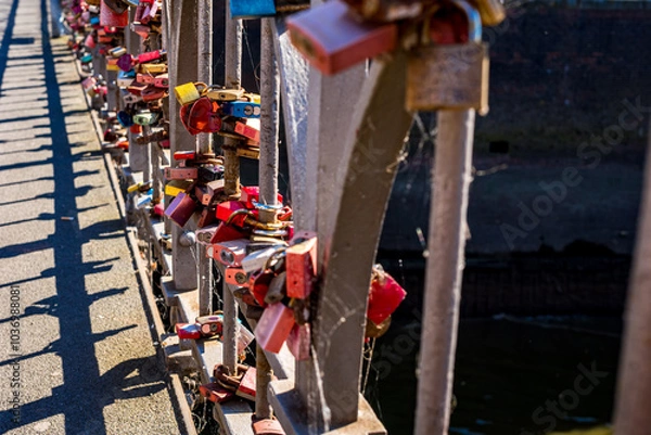 Fototapeta Love locks on a bridge railing represent enduring commitments and the unbreakable bond of romance, ideal for promoting marriage and unity at famous romantic travel destinations around the world.