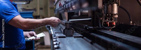 Fototapeta pracownik trzyma metalową płytkę