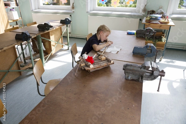 Fototapeta Little boy is working for a boat. 