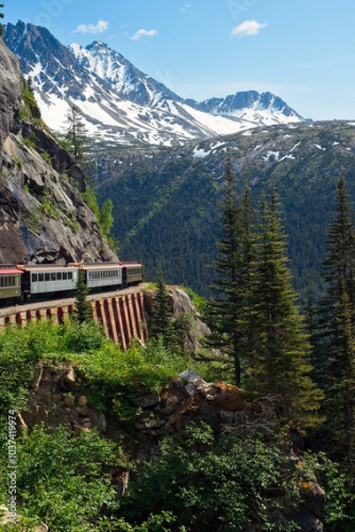 Fototapeta A scenic passenger train rounding a curve high in the mountains  above Skagway, Alaska