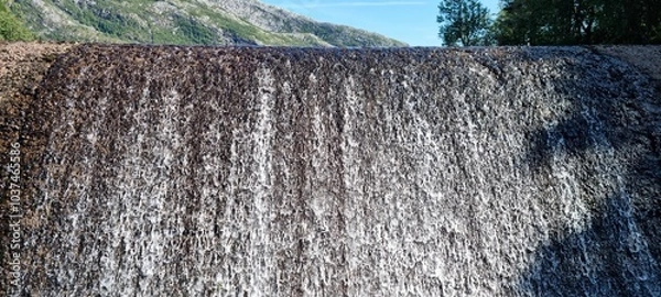 Fototapeta water flowing over small concrete dam connected to hydro electrical power production