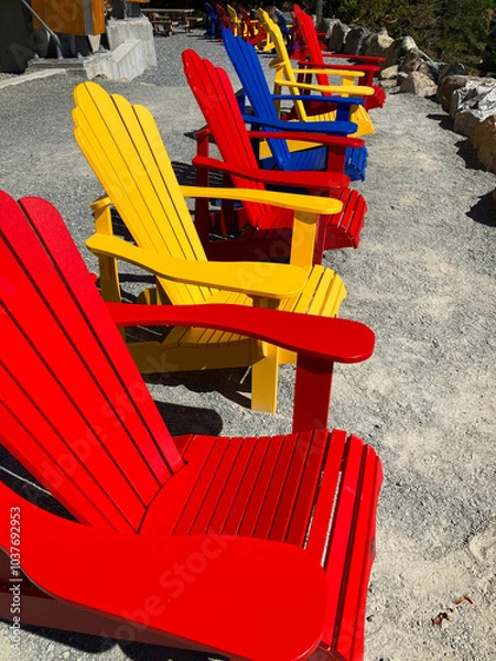 Obraz An image of several brightly painted deck chairs lined up in a row with a view of the Pacific Ocean. 