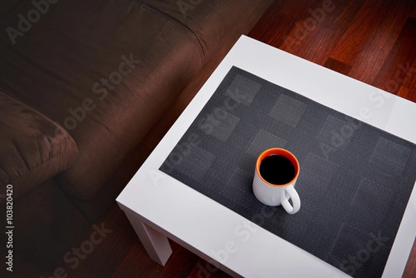 Fototapeta 
Cup of coffee on a white coffee table in a living room. Concept of lazy afternoon.
