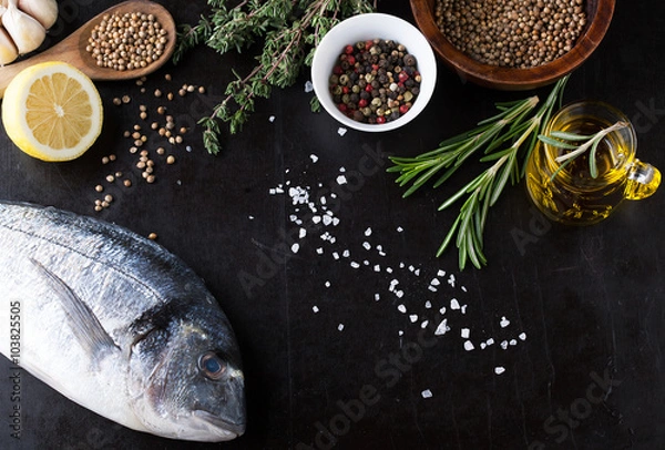 Fototapeta Fresh fish dorado with fragrant spices, herbs and spices