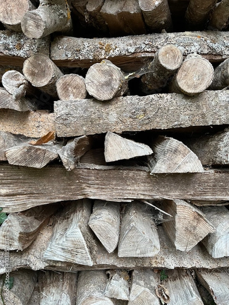 Obraz Round an triangular logs, stacked in an unusual manner