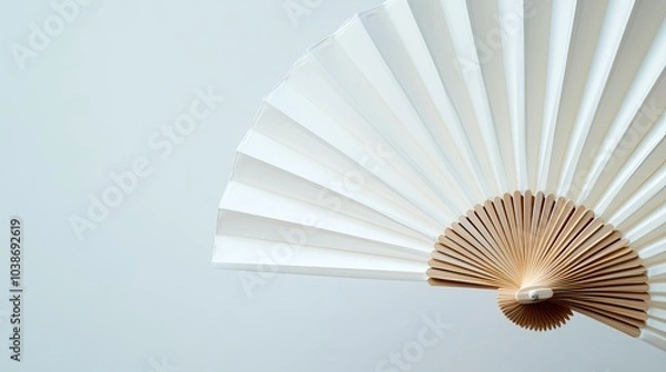 Fototapeta Close-up view of a white folding hand fan, fully opened against a bright white background for product mockup.