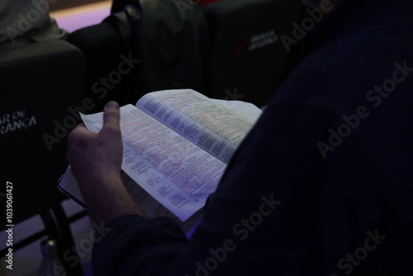 Fototapeta Close-up of a man's hands holding a Holy Bible, symbolizing faith and devotion. The image captures the essence of spirituality and reflection, inviting a deeper connection to religious traditions.
