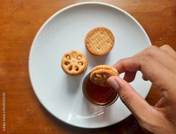 Fototapeta various kinds of biscuits that are usually eaten at breakfast accompanied by a glass of hot coffee on a white plate